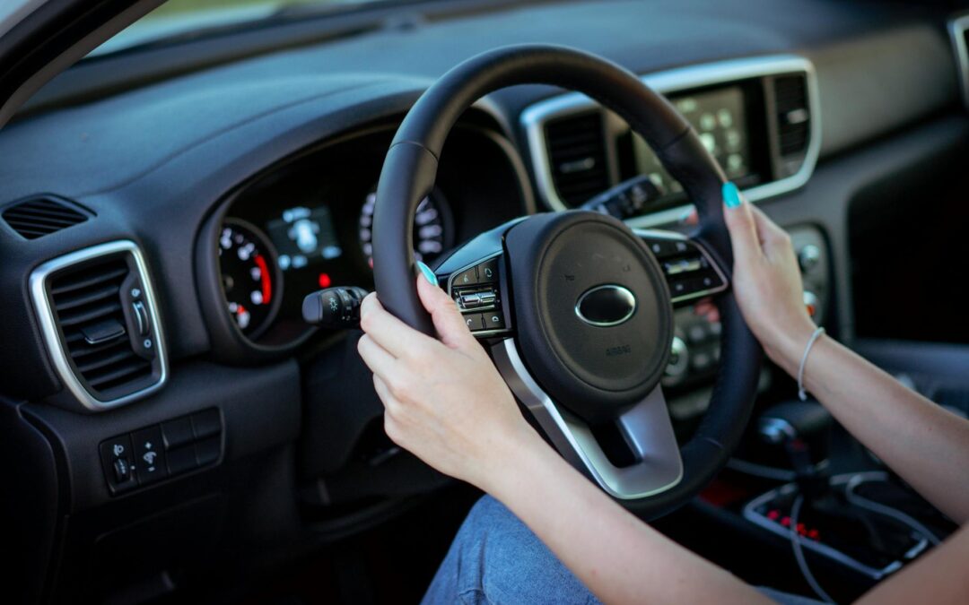 woman hands holding steering wheel