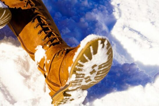 person s left foot on snowfield